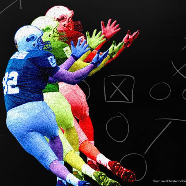 Football player about to catch a ball, with X's and O's diagram in background