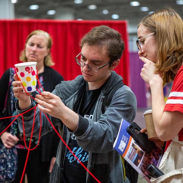 2019 Festival attendees focusing on string puzzle