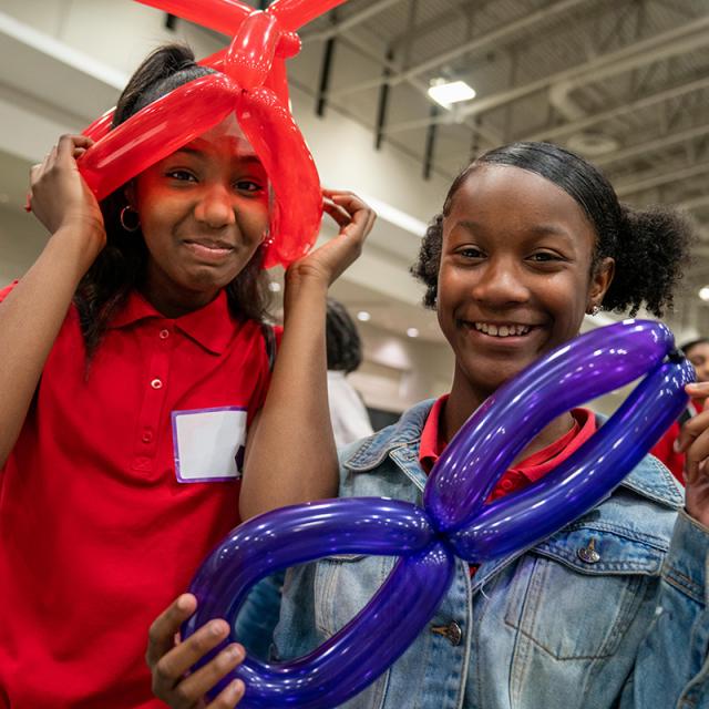 Two girls with twisted balloons at National Math Festival 2019